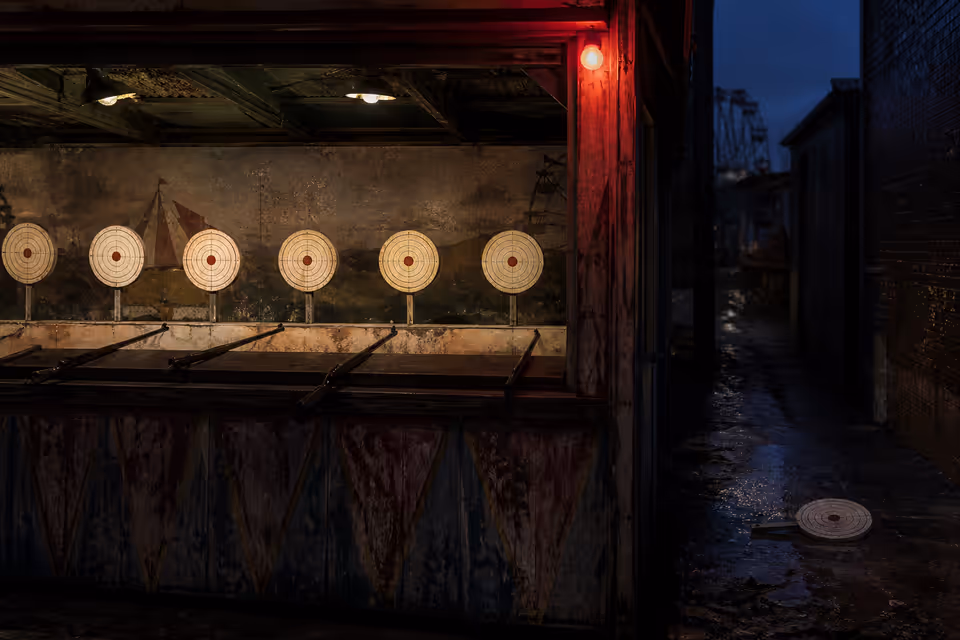Fairground shooting gallery with the targets hit dead centre, one target knocked over in the shadows