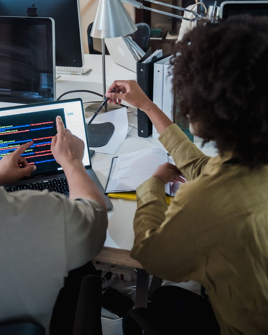 Two developers reading code together on screen during a code review.